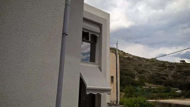 Κουρμπωτή τέντα (καπότα) πάνω από παράθυρο