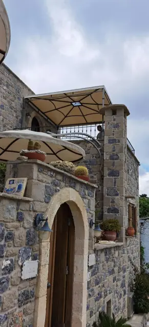 Κουρμπωτή τέντα σε πέτρινη κατοικία