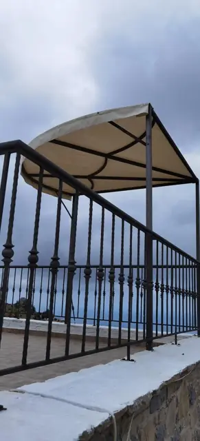 Κουρμπωτή τέντα σε μπαλκόνι