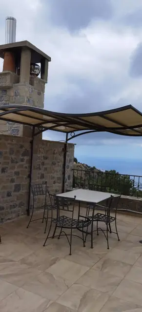 Κουρμπωτή τέντα πάνω από τραπεζαρία βεράντας
