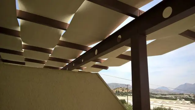 Κυματιστό ύφασμα σε ξύλινη πέργκολα με θέα στο βουνό