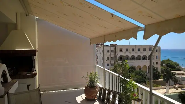 Τέντα με αντηρίδες και κάθετη τέντα σε βεράντα με θέα στη θάλασσα