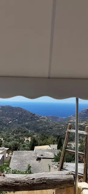Τέντα με αντηρίδες και βολάν σε βεράντα με θέα στη θάλασσα