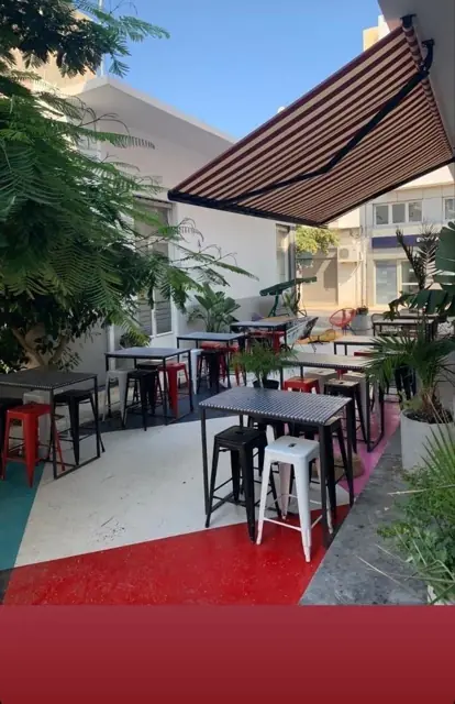 Ριγέ τέντα με βραχίονες σε αυλή καφετέριας