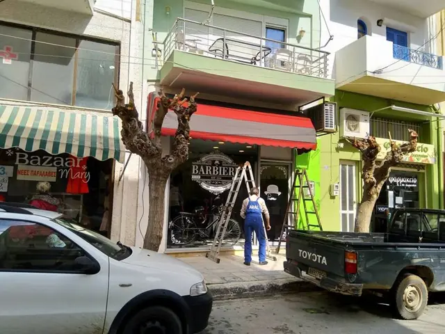 Γκρι-κόκκινη τέντα καταστήματος σε εμπορικό δρόμο